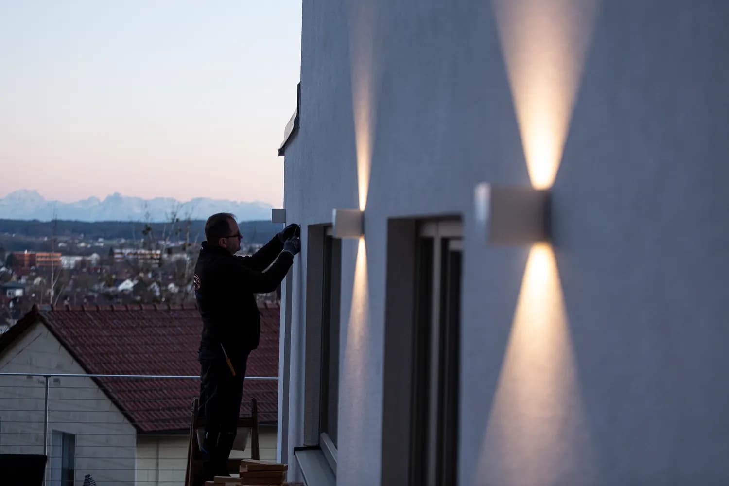 Montierte Fassaden-Wandleuchte an einem Wohnhaus in der Abenddämmerung