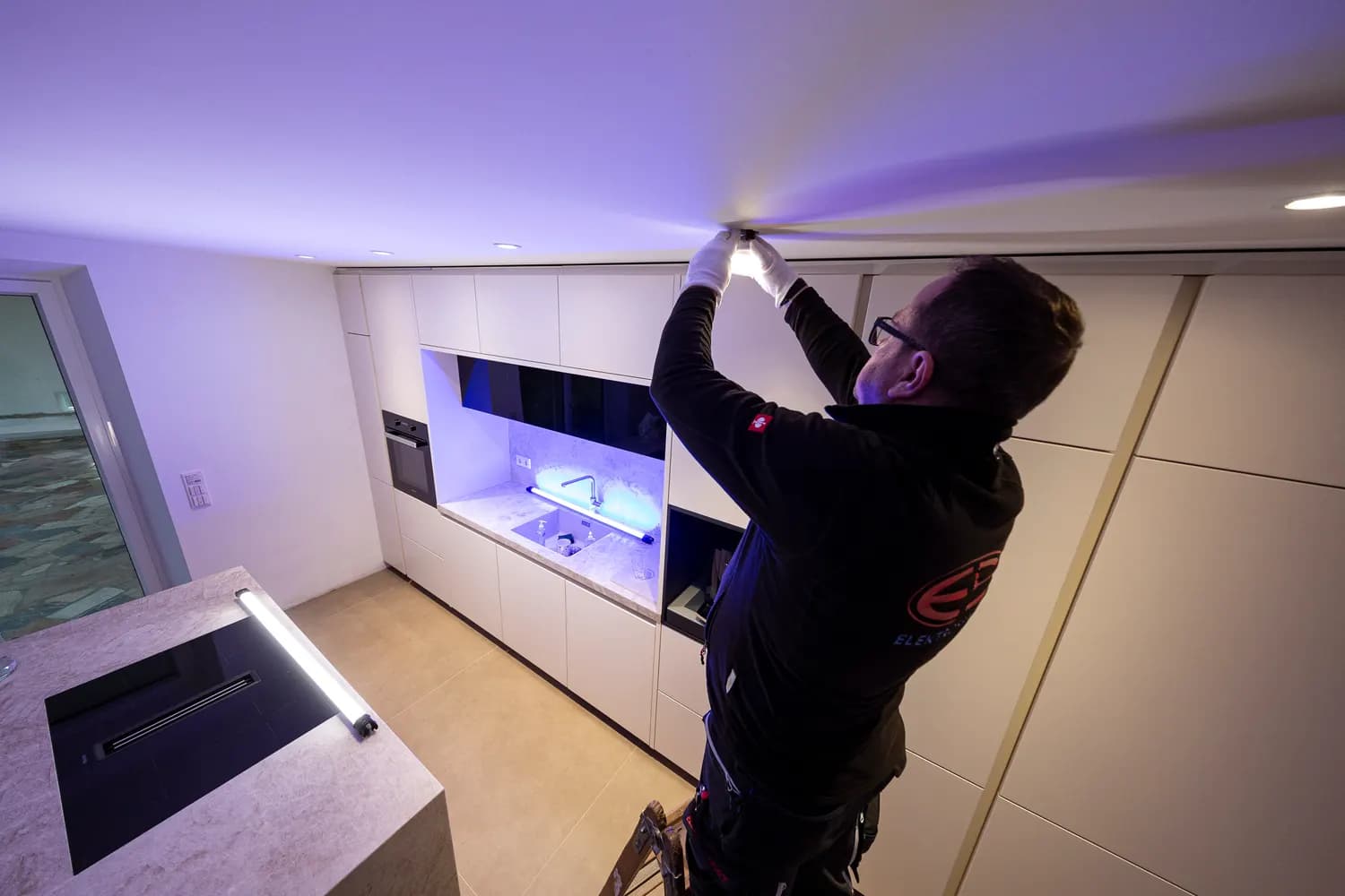 Montage moderner Deckenbeleuchtung in einem Wohnraum